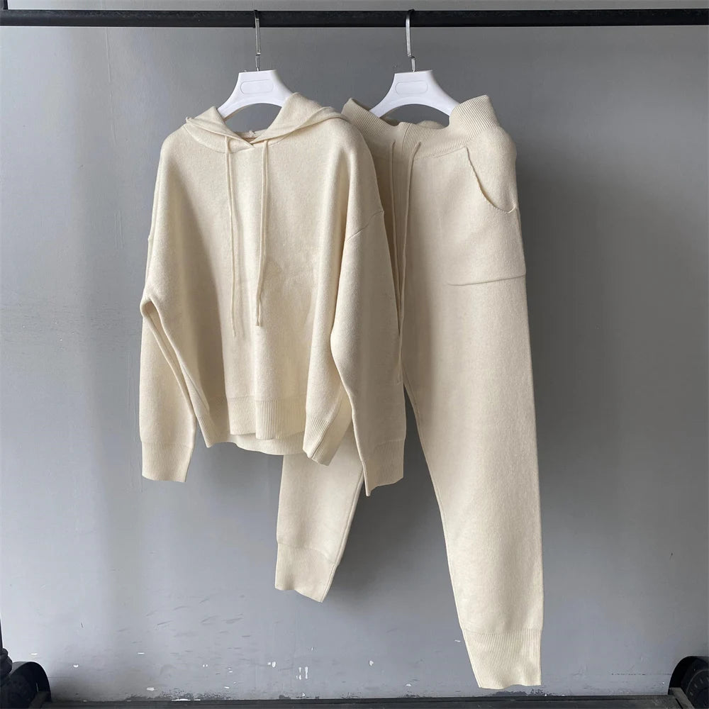 Beige hoodie and pants set hanging on a gray background