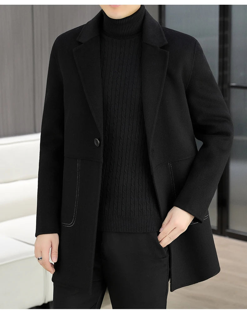 Person wearing a black coat over a black sweater and pants in an indoor setting.
