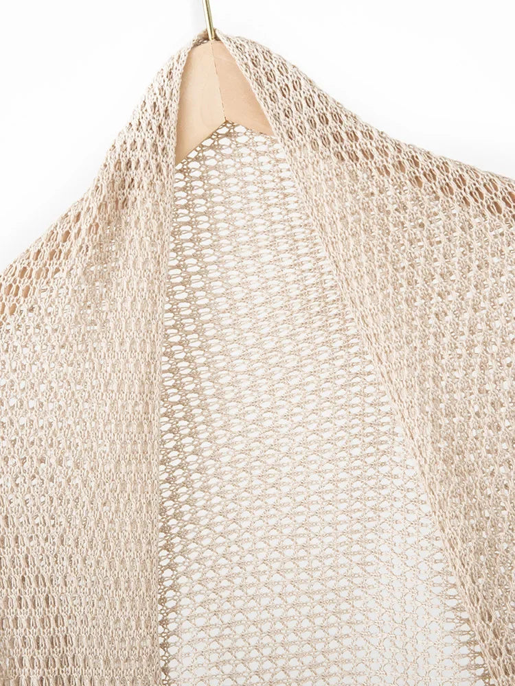 Beige knitted shawl on a hanger against a white background