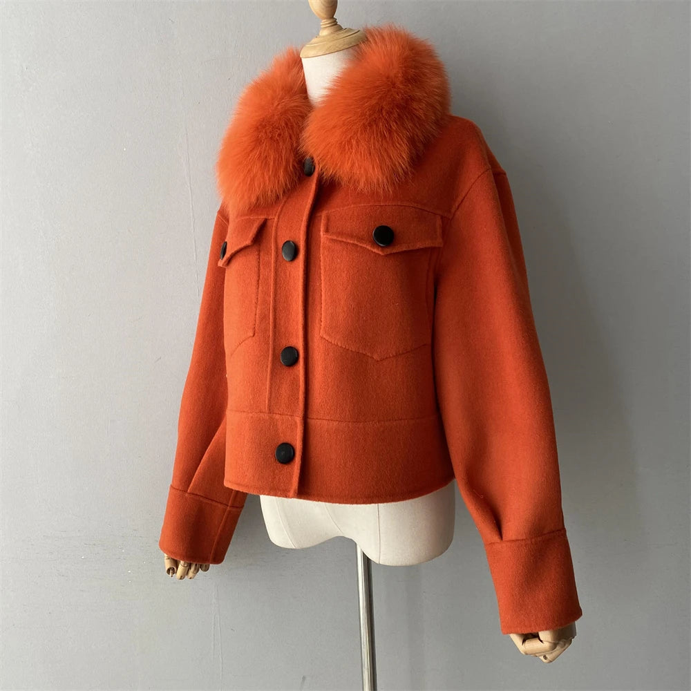 Orange coat with fur collar on a mannequin against a gray background