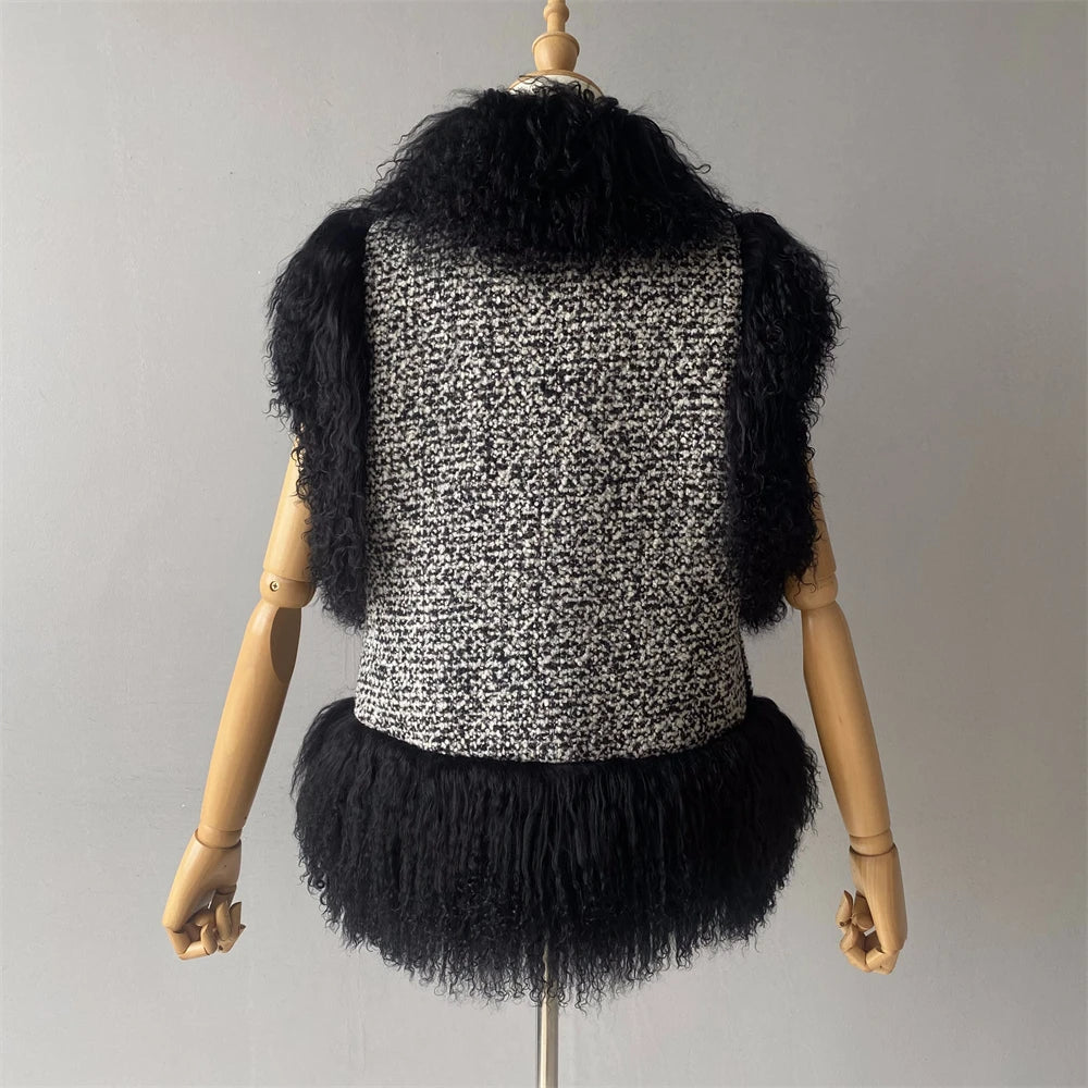 Black and white patterned vest with fringes on a mannequin against a gray background