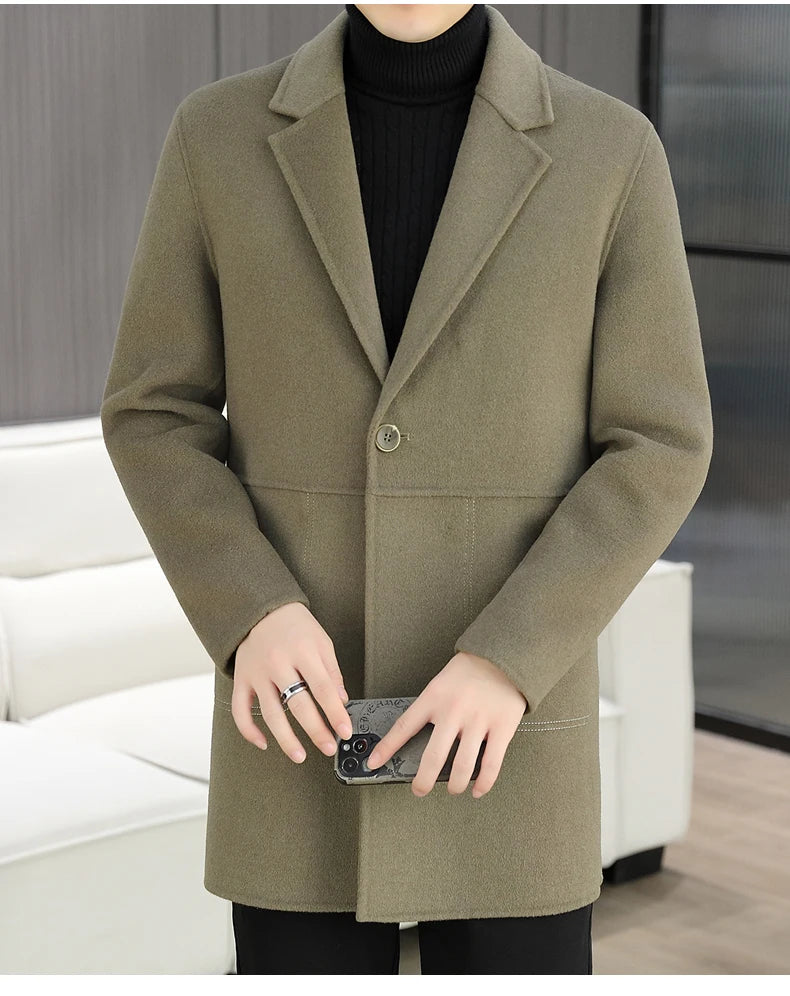 Person wearing a green coat holding a phone in an indoor setting