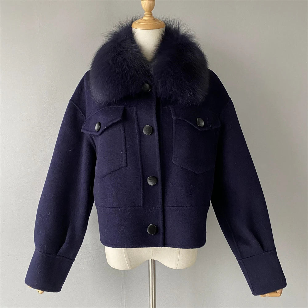 Navy blue coat with fur collar on a mannequin against a plain background