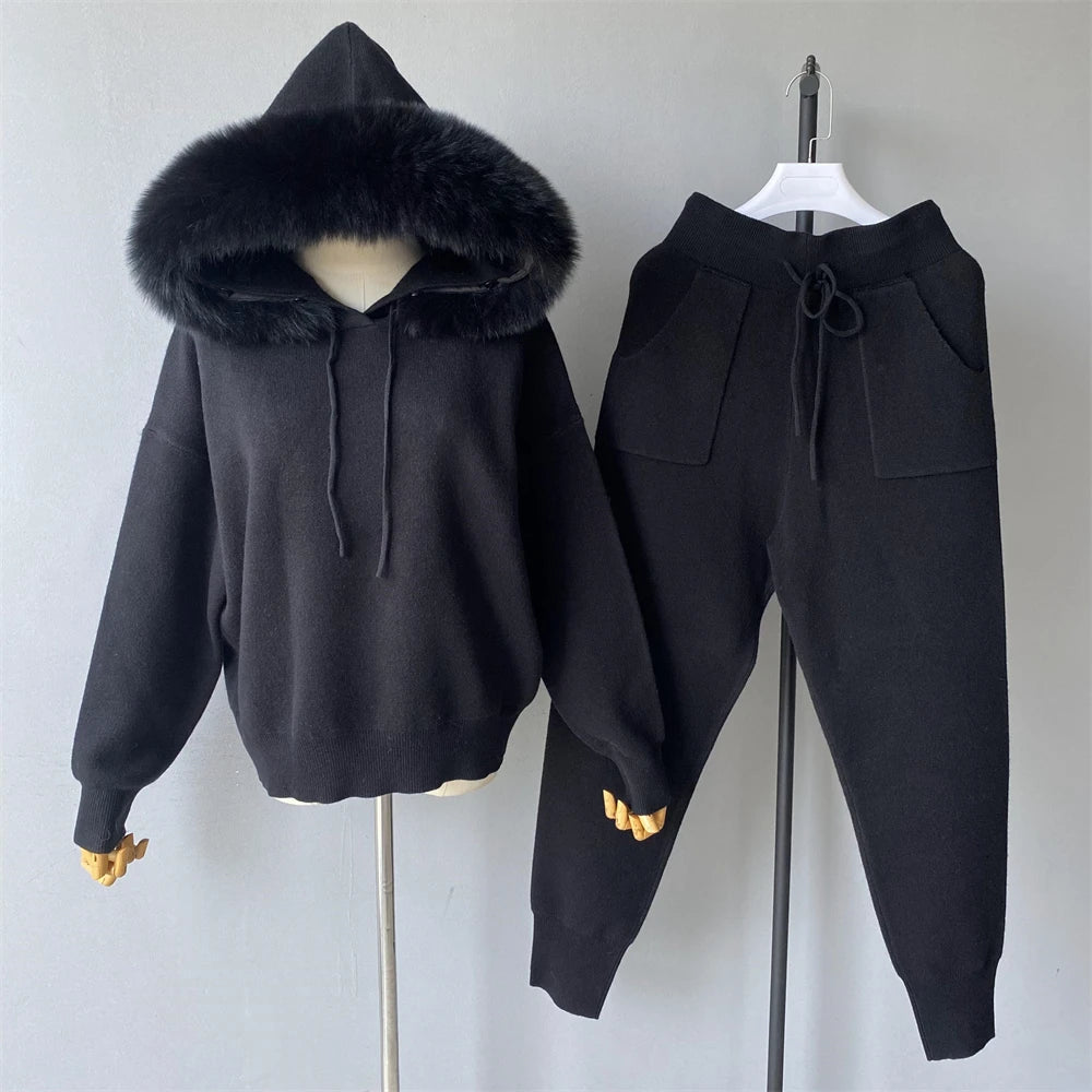 Black hoodie with fur-lined hood and matching pants on a gray background