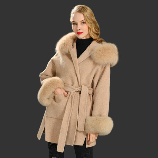 Woman wearing a beige coat with fur trim on a gray background