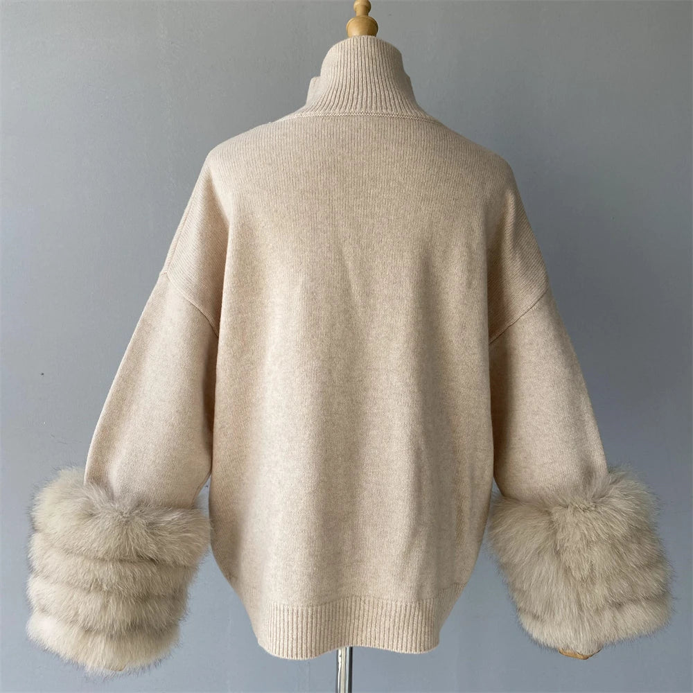 Beige sweater with fur cuffs on a mannequin against a gray background