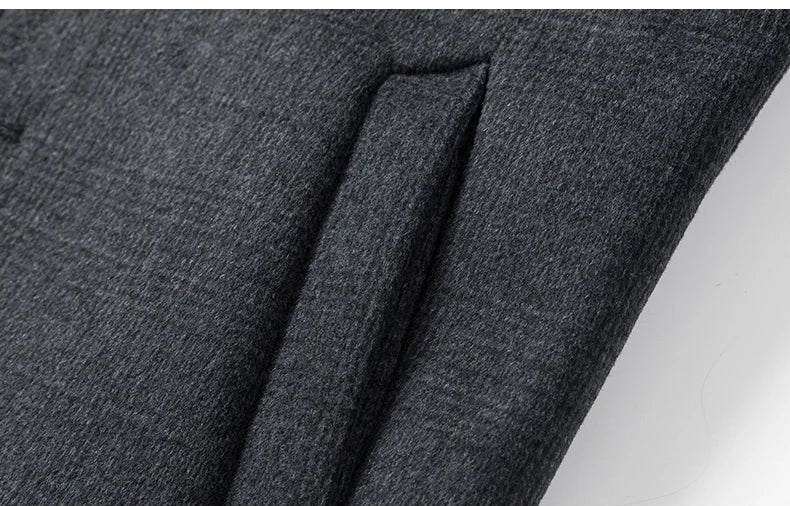 Close-up of dark gray fabric with a pocket detail on a white background