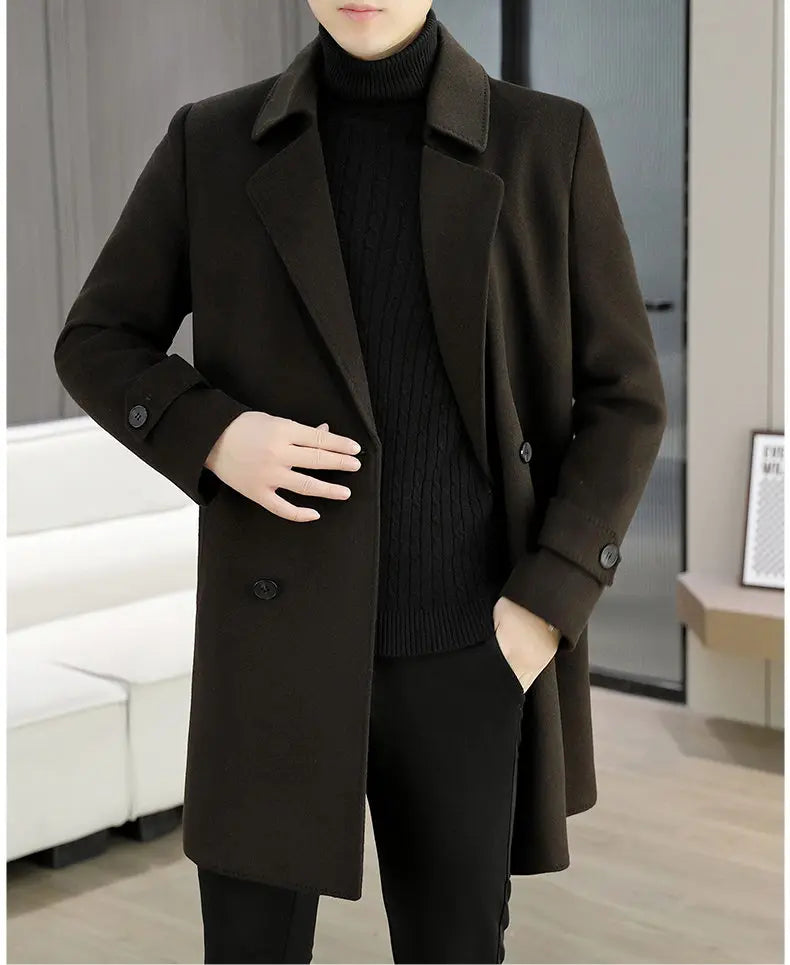 Person wearing a dark brown coat over a black sweater and pants in an indoor setting.