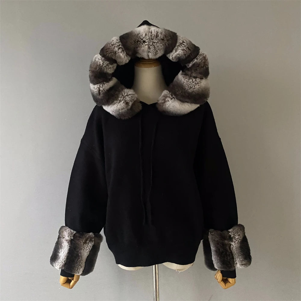 Black coat with fur trim on a mannequin against a neutral background