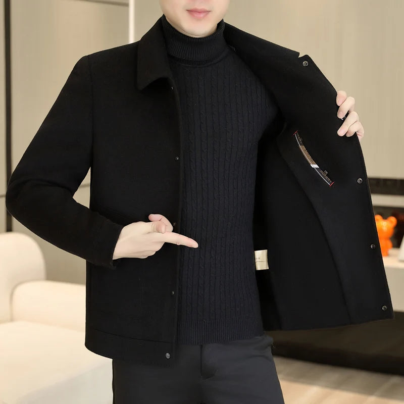 Person wearing a black coat over a black sweater in an indoor setting