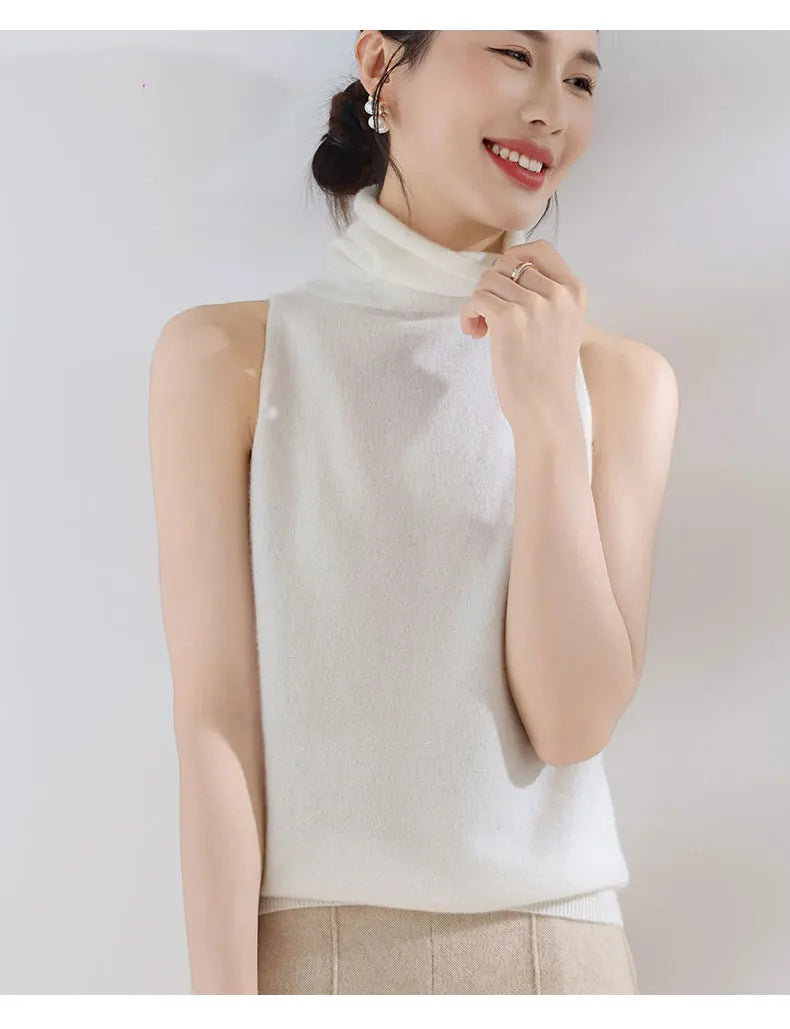 Woman wearing a white turtleneck top against a plain background