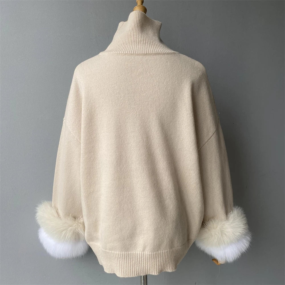 Beige sweater with fur cuffs on a mannequin against a gray background