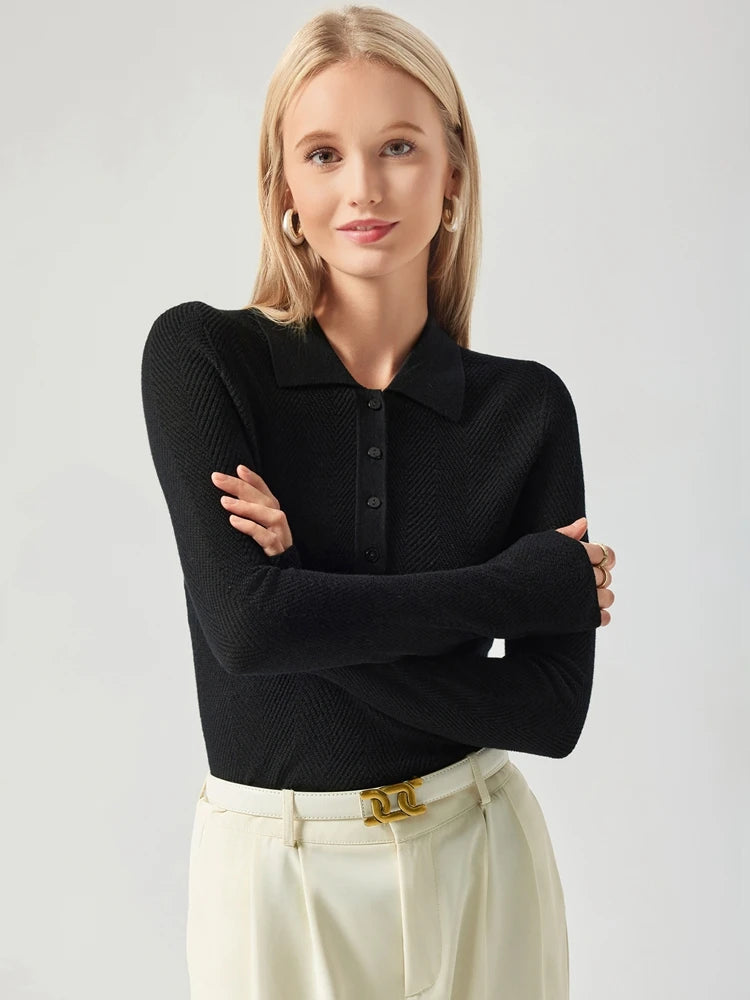 Woman wearing a black textured shirt and white pants with a gold belt against a light gray background