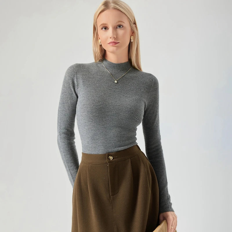 Woman wearing a gray sweater and brown skirt on a light gray background