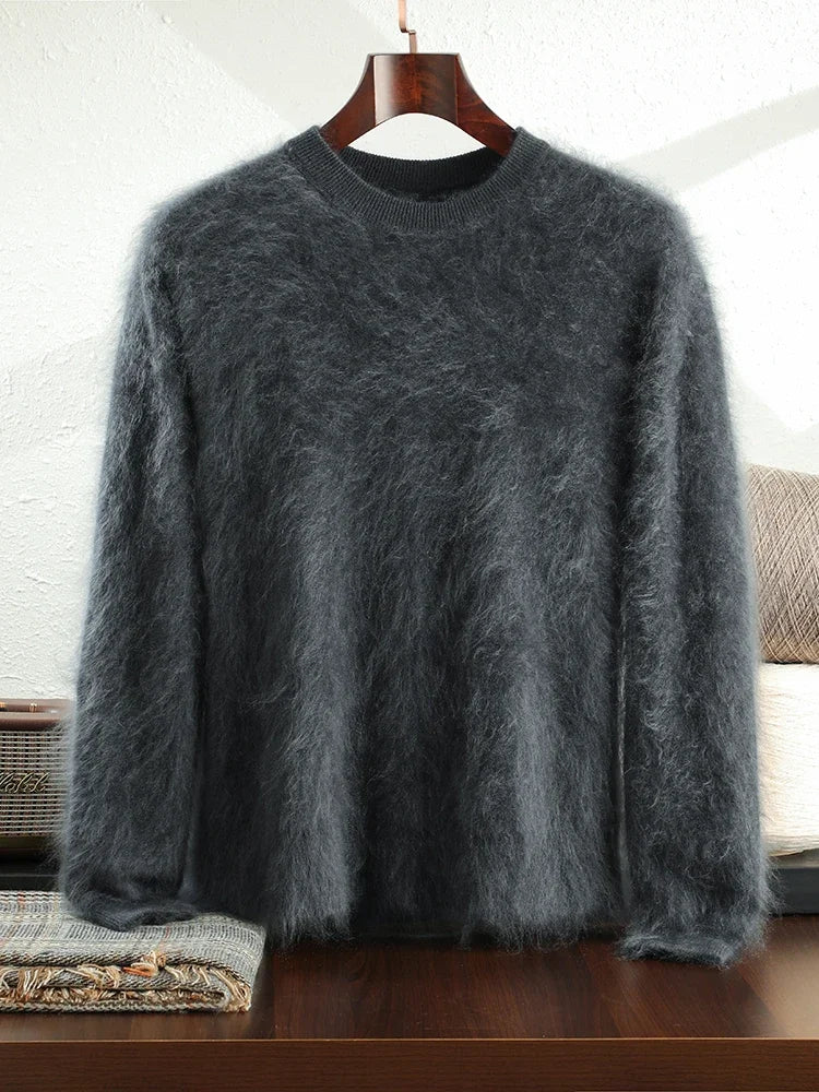 Gray fuzzy sweater on a hanger against a white wall.