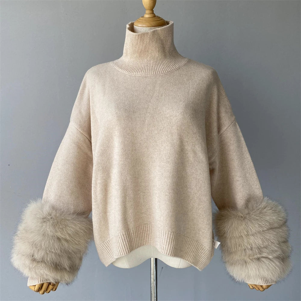 Beige sweater with fur cuffs on a mannequin against a gray background