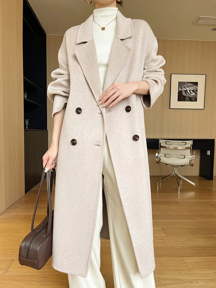 Person wearing a long beige coat in an indoor setting