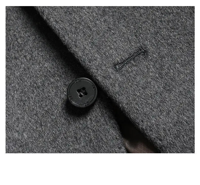 Close-up of a gray coat with a button and brand logo.