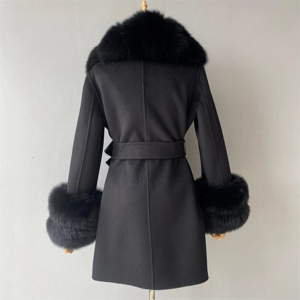 Black coat with fur trim on a mannequin against a plain background