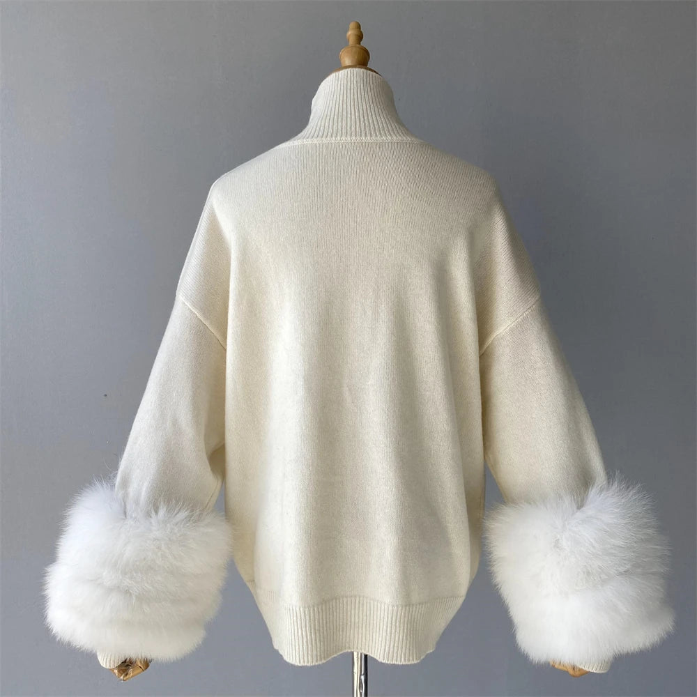 White sweater with fur cuffs on a mannequin against a gray background