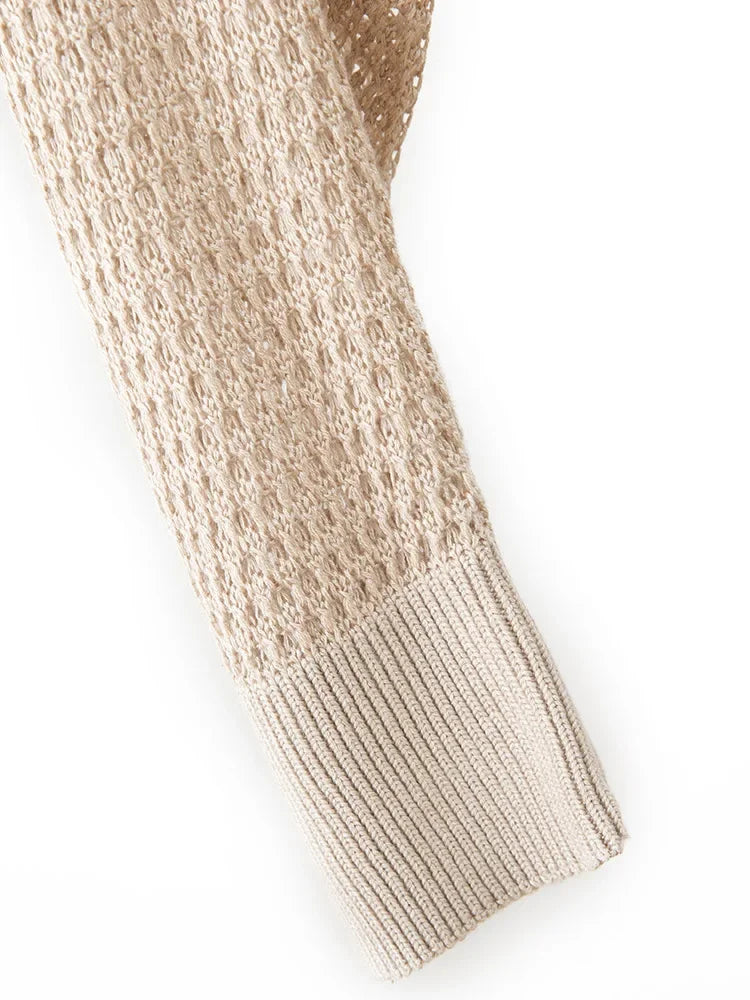 Close-up of a beige knitted sweater sleeve on a white background
