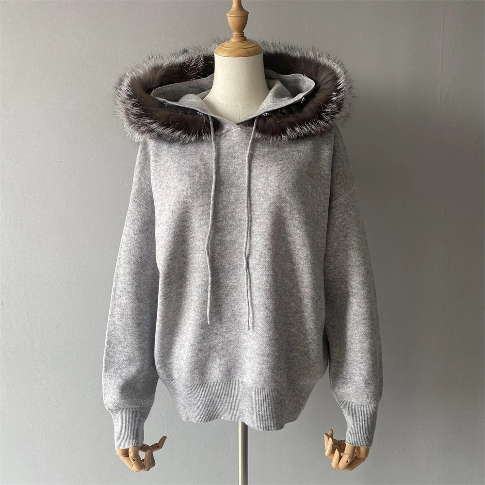 Gray hoodie with brown fur hood on a mannequin against a plain background