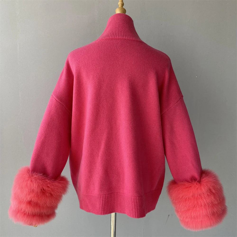 Pink sweater with fur cuffs on a mannequin against a plain background