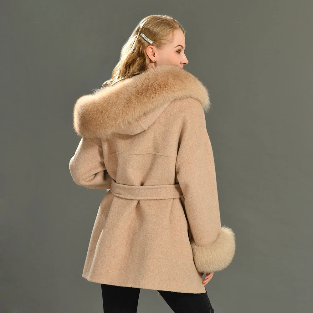 Woman wearing a beige coat with fur trim on a gray background