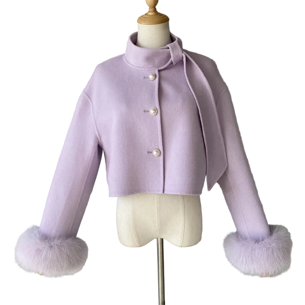 Lavender coat with fur cuffs on a mannequin against a gray background