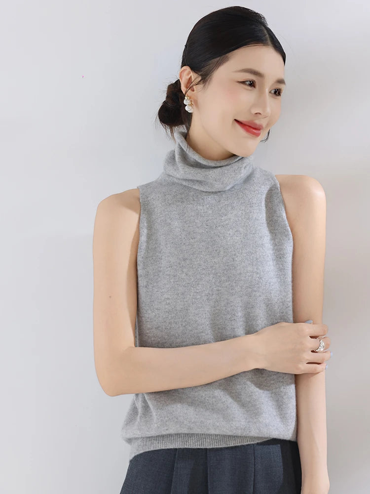 Woman wearing a gray sleeveless top against a plain background
