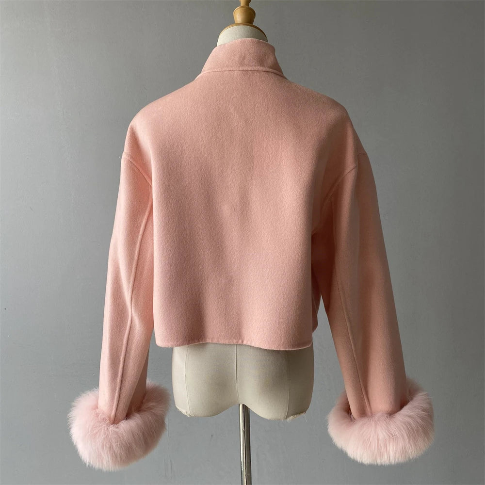 Pink jacket with fur cuffs on a mannequin against a gray background