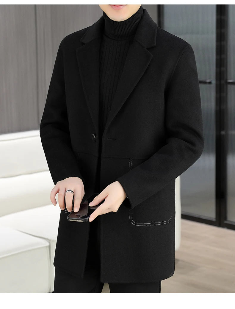 Person wearing a black coat holding a phone in an indoor setting