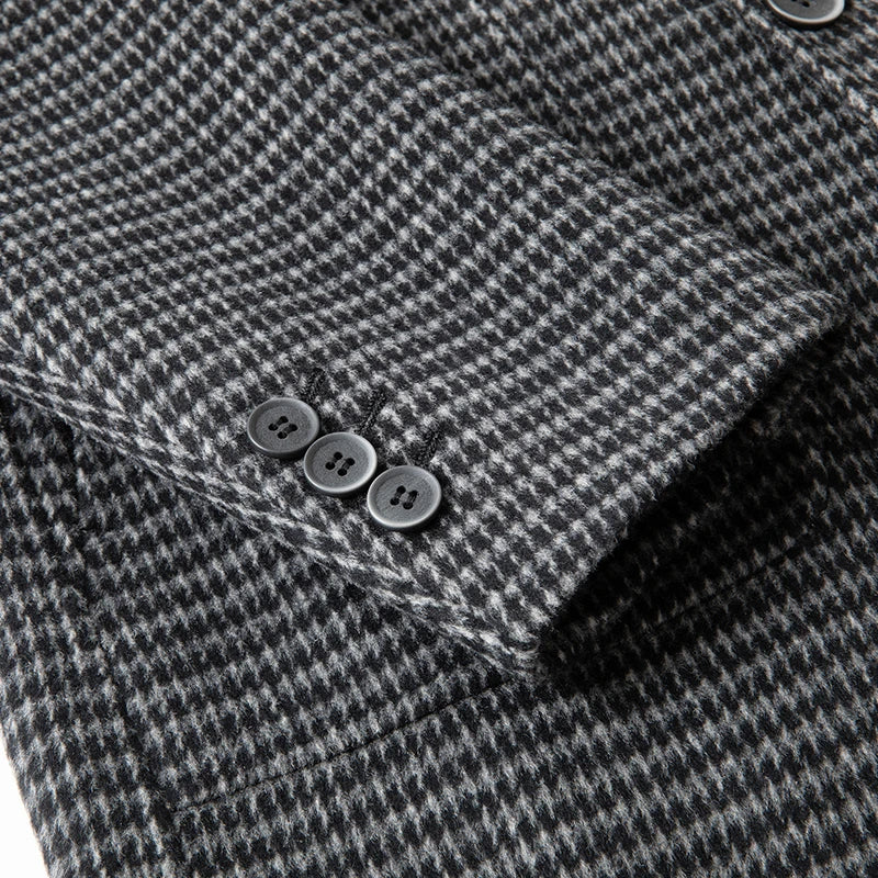 Close-up of a gray and black houndstooth patterned fabric with buttons.