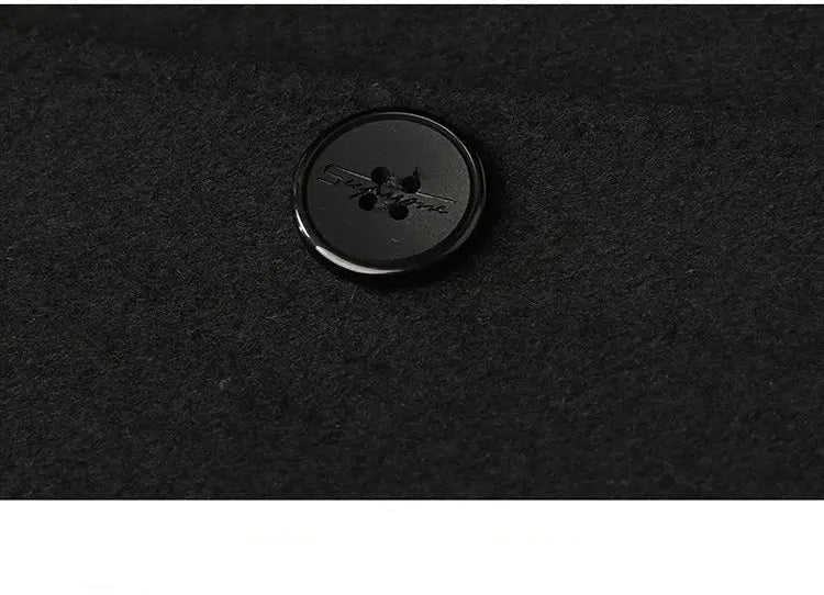 Black button on a textured black fabric background
