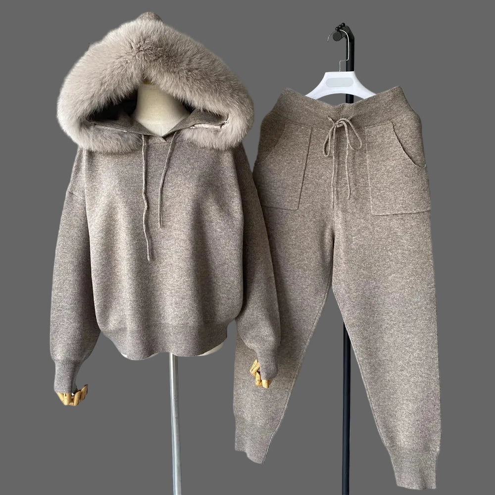 Brown hoodie and pants set on hangers against a gray background