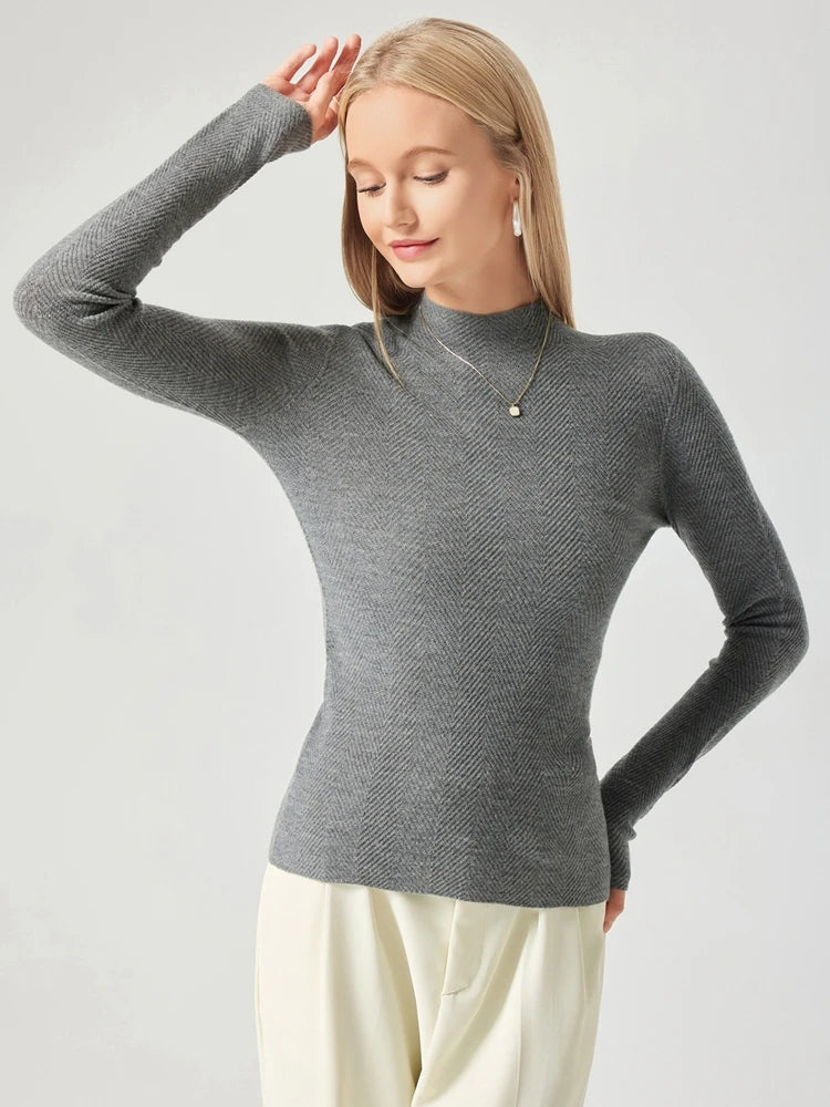 Woman wearing a gray turtleneck sweater against a white background