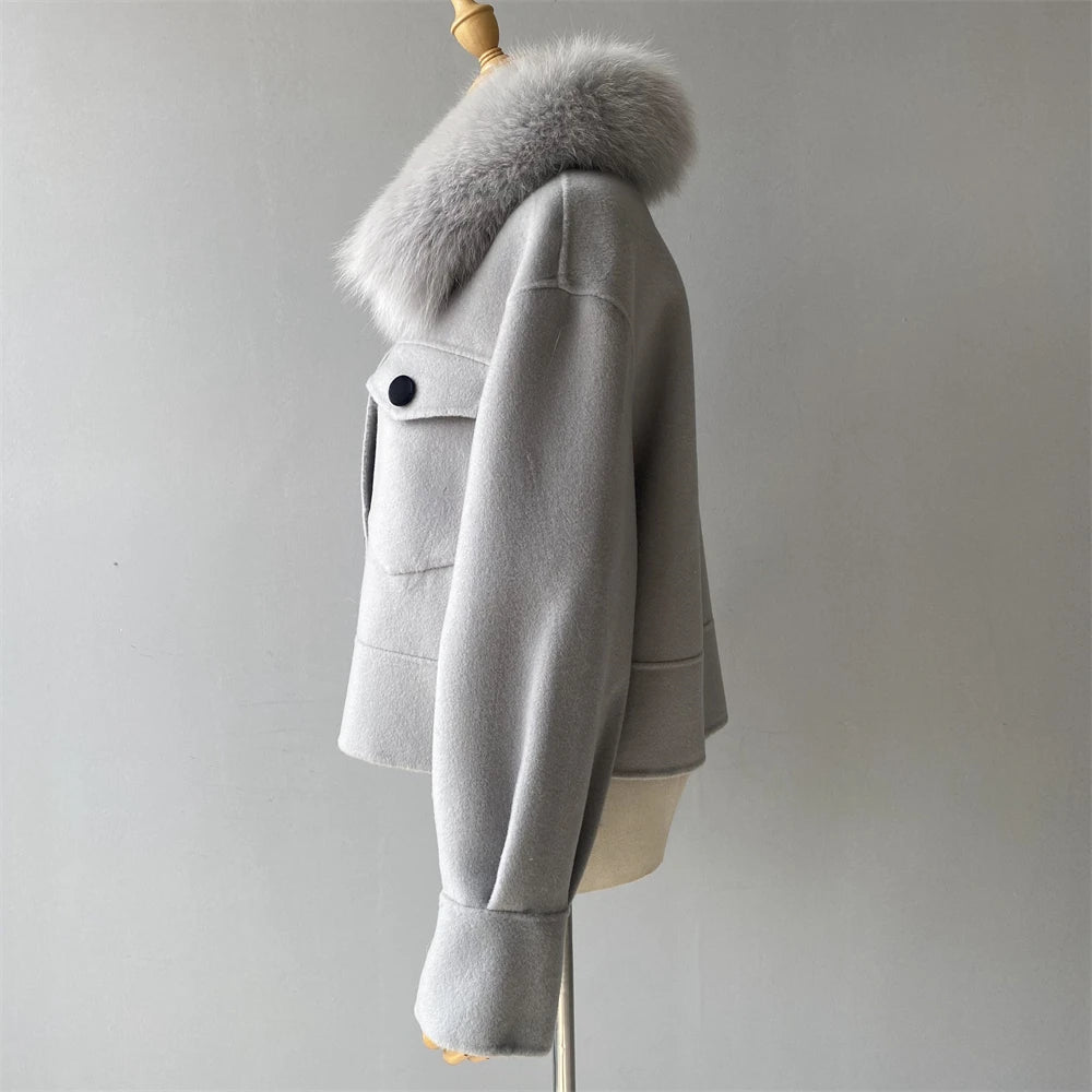 Gray coat with fur hood on a mannequin against a plain background