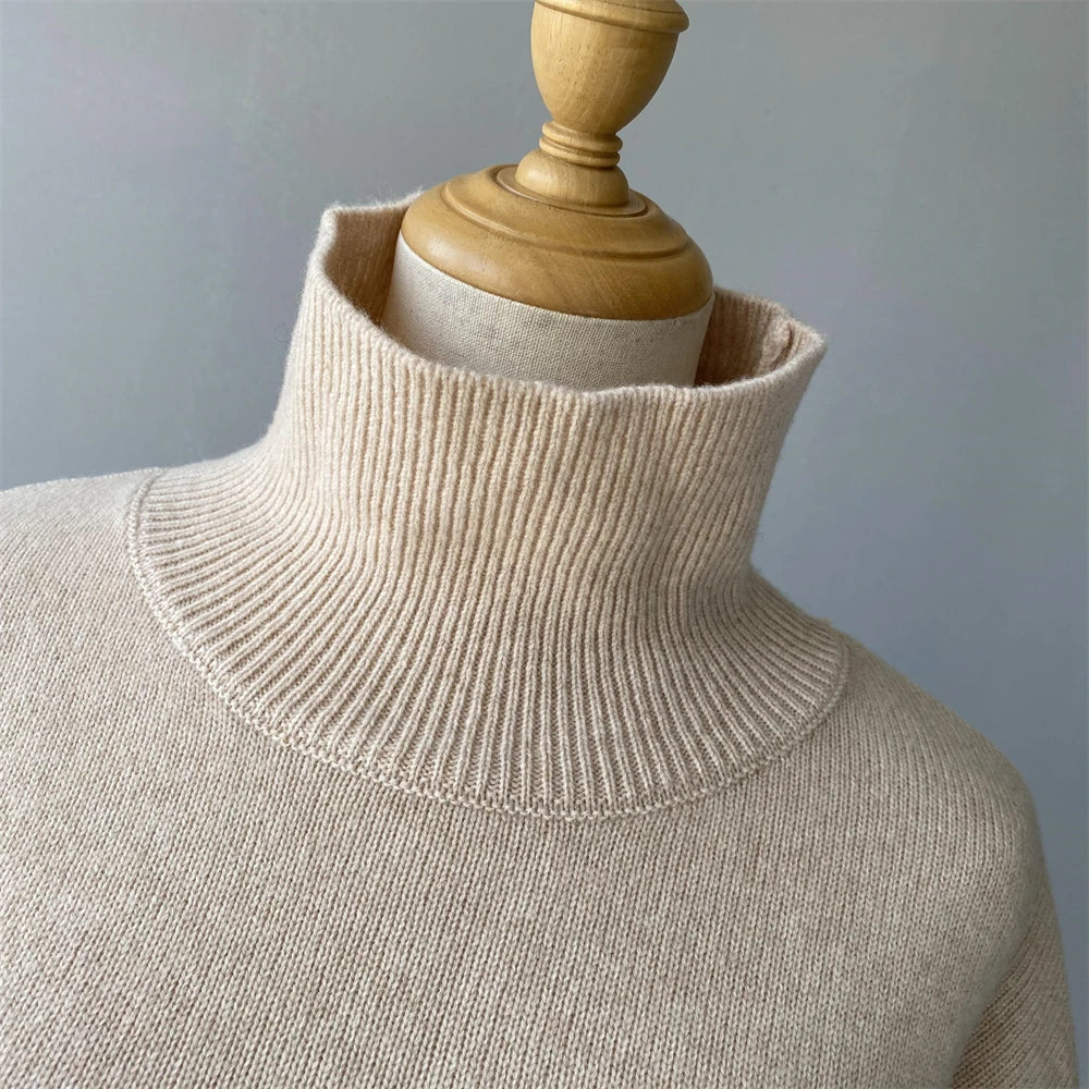 Beige turtleneck sweater on a mannequin against a gray background