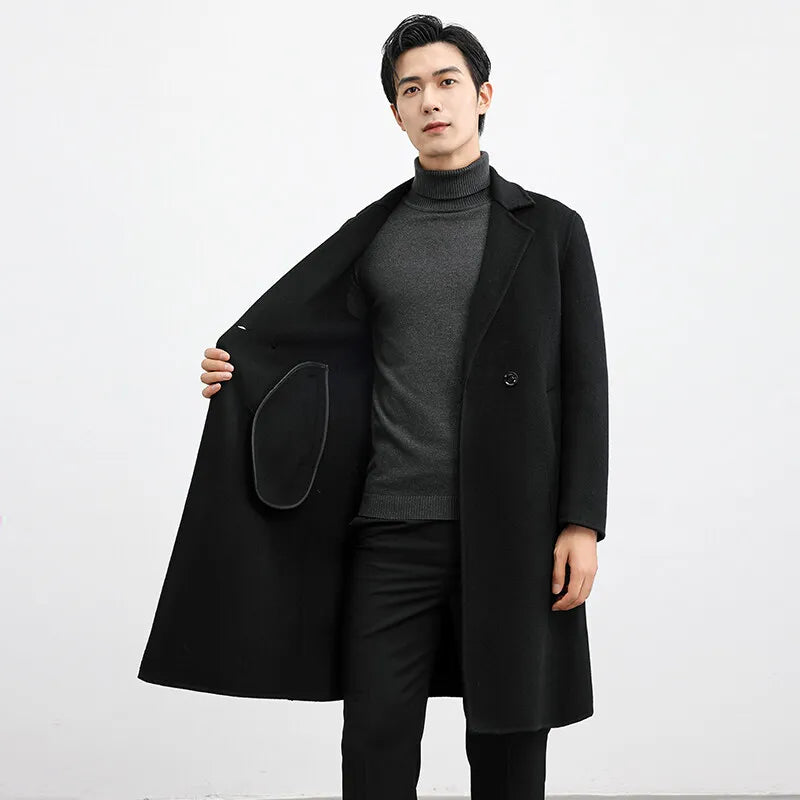 Man wearing a black coat over a gray sweater on a white background