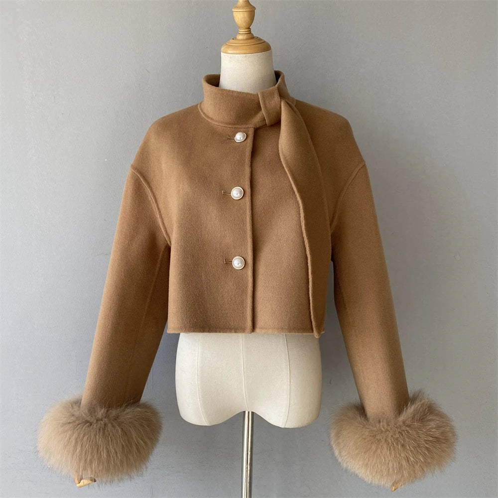 Brown jacket with fur cuffs on a mannequin against a gray background