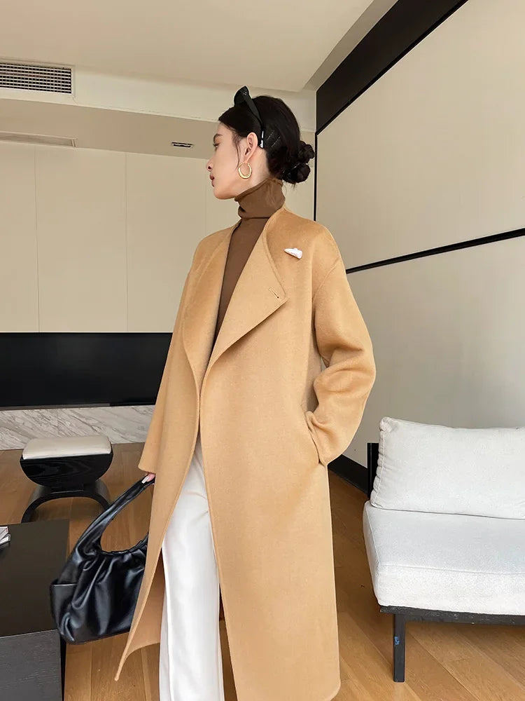 Person wearing a beige coat in an indoor setting
