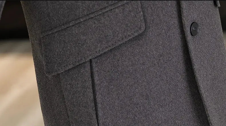 Close-up of a gray coat with a pocket and button, blurred background