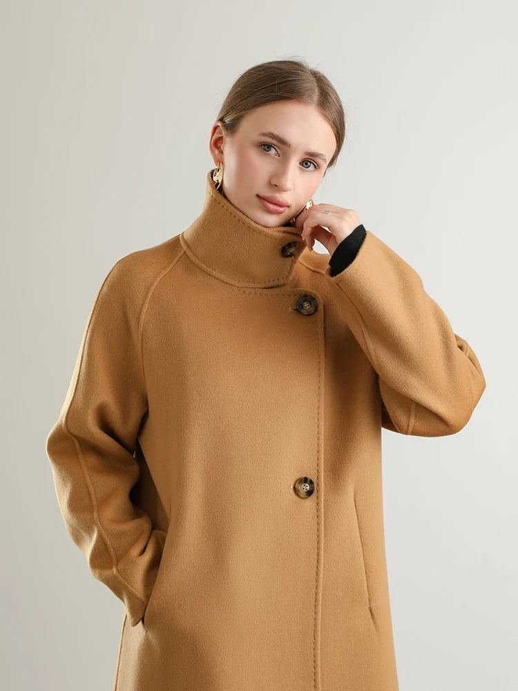 Woman wearing a brown coat against a plain background