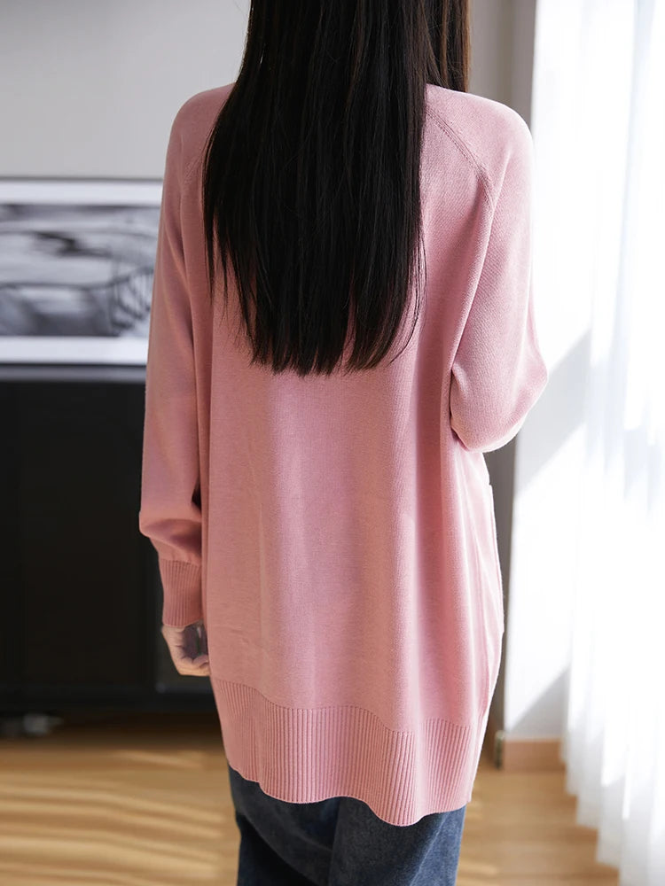 Person wearing a pink sweater in an indoor setting