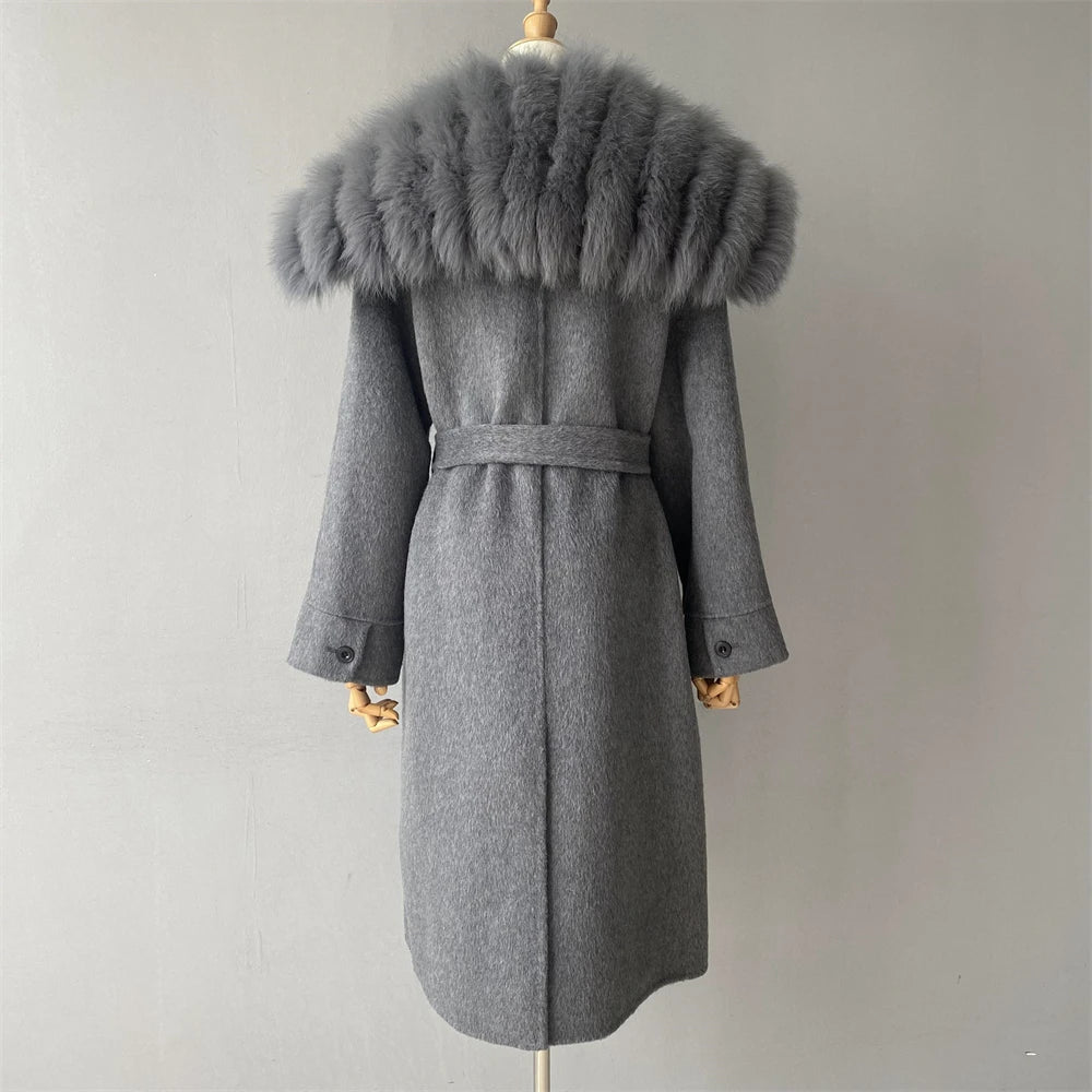 Gray coat with fur hood on a mannequin against a plain background