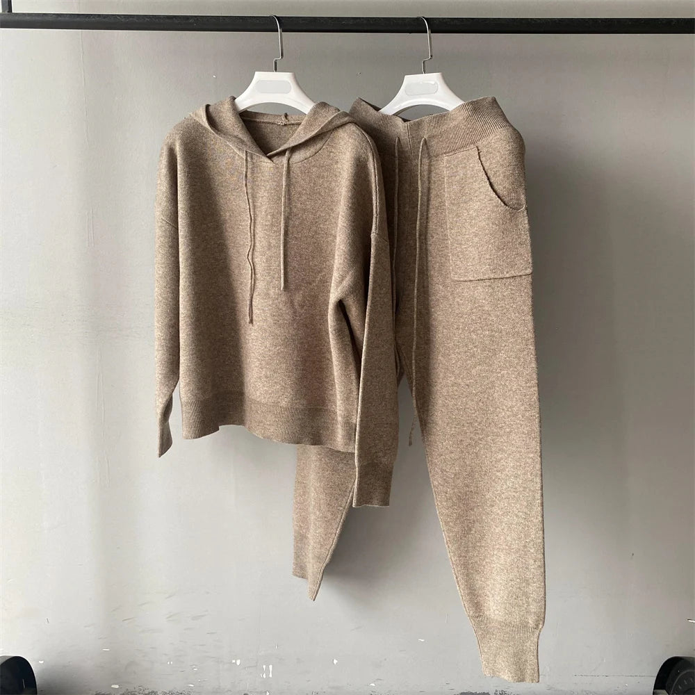 Brown hoodie and pants set on hangers against a plain background