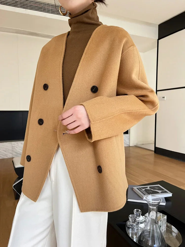 Person wearing a brown coat with black buttons in an indoor setting