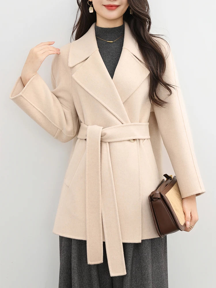 Woman wearing a beige coat with a plain background