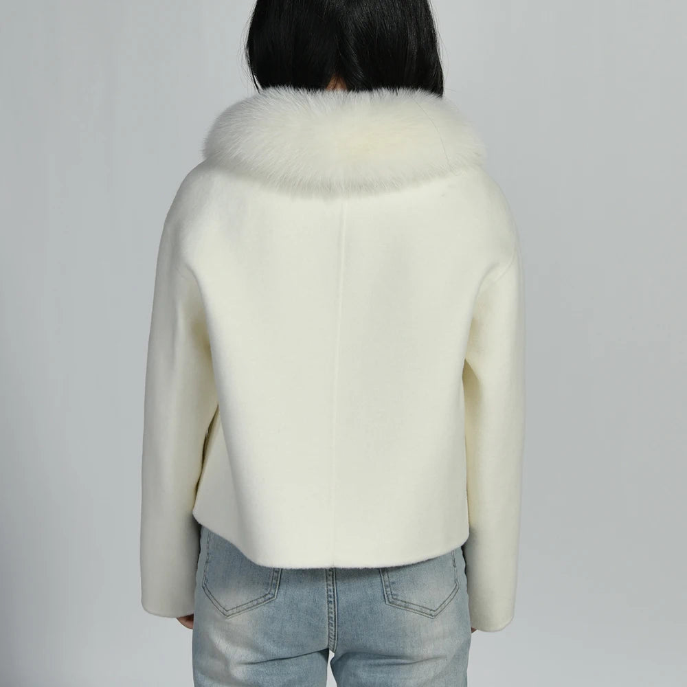 White coat with fur collar worn by a person on a plain background
