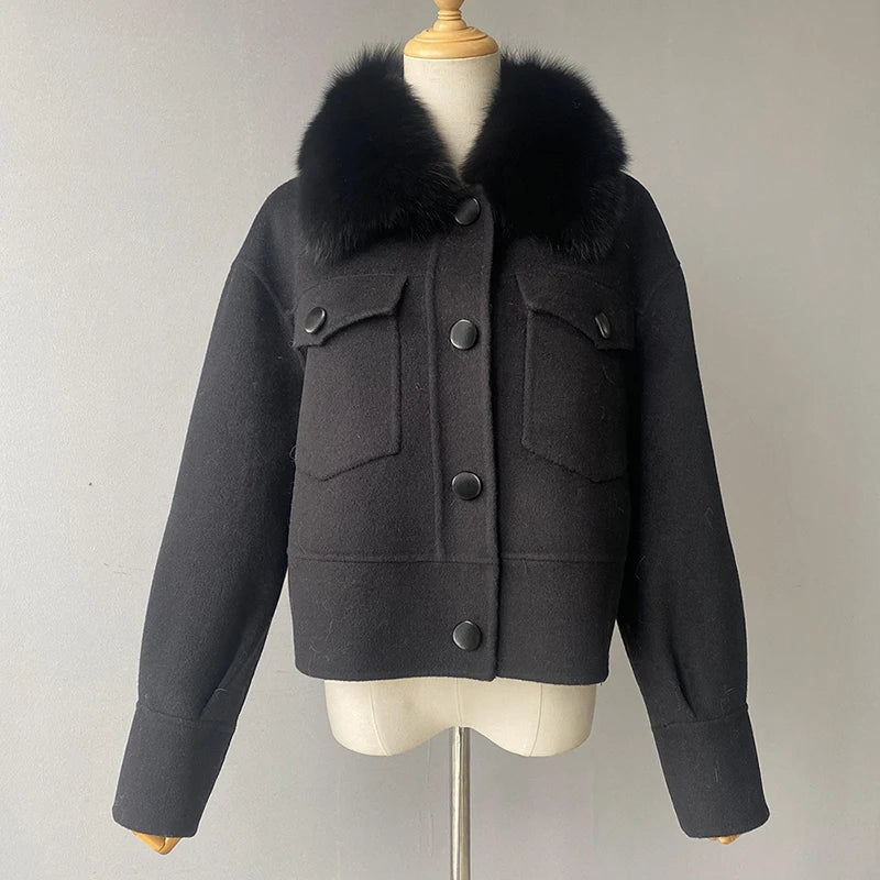 Black coat with fur collar on a mannequin against a plain background